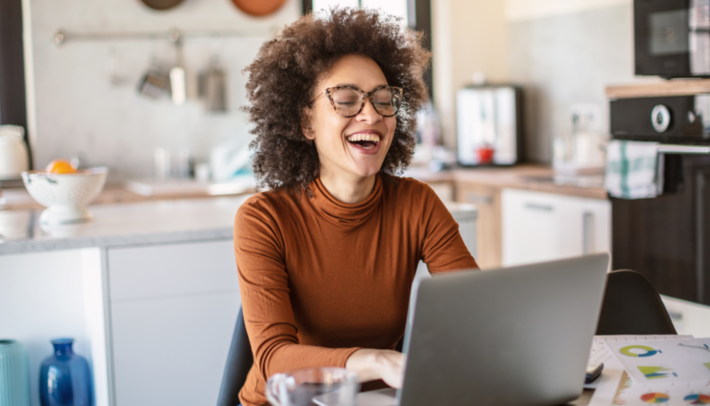 Lady laughing work from home from her kitchen table